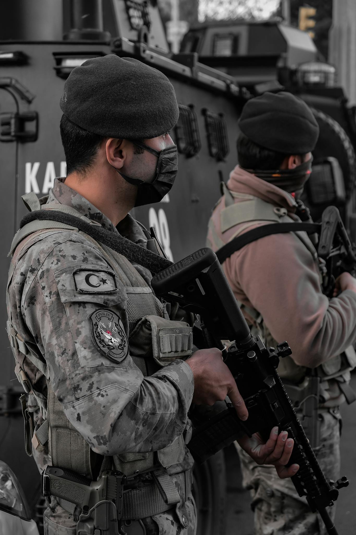 Turkish soldiers wearing masks and carrying firearms stand by an armored vehicle in Istanbul.